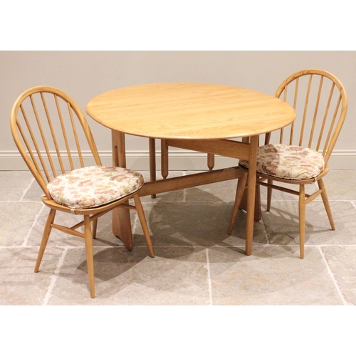 783 - An Ercol blonde elm drop leaf breakfast table, late 20th century, the oval top raised upon trestle t... 