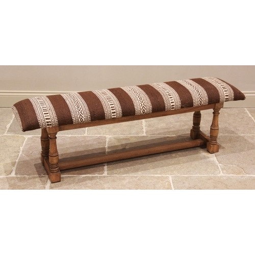 788 - An upholstered hardwood long stool or window seat, late 20th/early 21st century, the rectangular pad... 