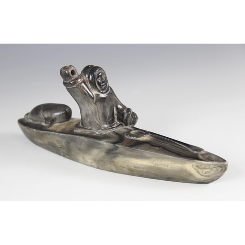 176 - A Inuit stone carving, modelled as a fisherman in a canoe/Umiak, 24.5cm long