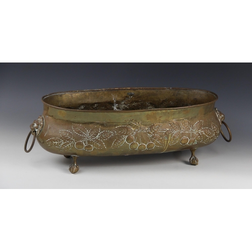 597 - A late Victorian brass planter, of oval form embossed with foliate and fruit motifs, lion mask loop ... 