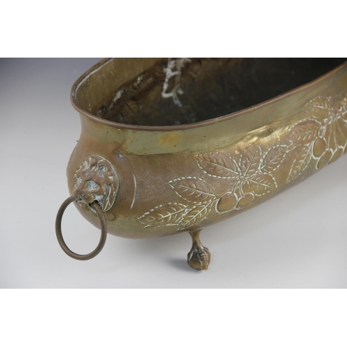 597 - A late Victorian brass planter, of oval form embossed with foliate and fruit motifs, lion mask loop ... 