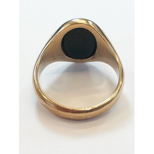 139 - A 9ct gold bloodstone set signet ring, the oval plain polished bloodstone matrix measuring 13.2mm x ... 