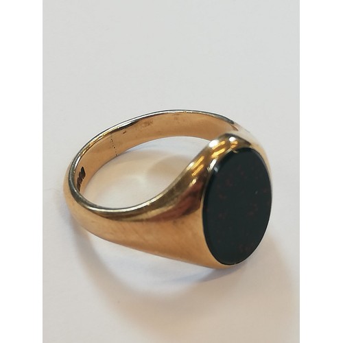 139 - A 9ct gold bloodstone set signet ring, the oval plain polished bloodstone matrix measuring 13.2mm x ... 