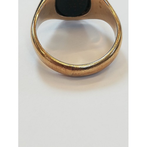 139 - A 9ct gold bloodstone set signet ring, the oval plain polished bloodstone matrix measuring 13.2mm x ... 