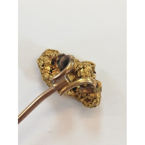 152 - A Victorian 'golden nugget' stick pin, the (untested) nugget measuring 20mm x 12mm, upon a gold colo... 