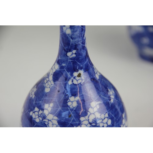 456 - A pair of Japanese porcelain bottle vases, 20th century, each decorated in blue and white with flora... 