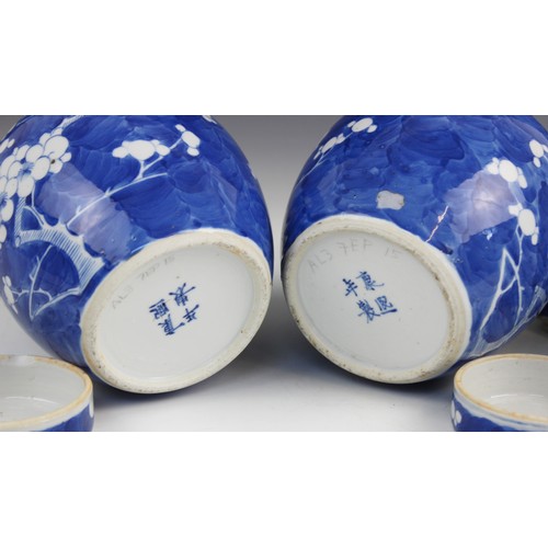 454 - A pair of Chinese porcelain blue and white prunus pattern ginger jars and covers, each of typical gl... 