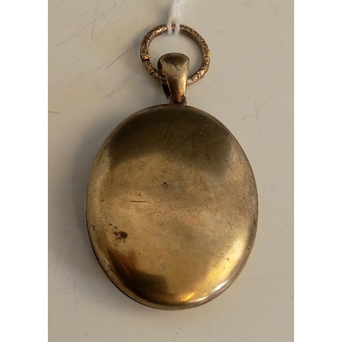 151 - A Victorian locket pendant, the unmarked gold coloured pendant of oval form, the cover with applied ... 