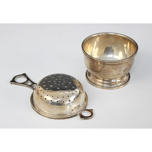 63 - A silver tea strainer and stand, G W Lewis & Co Birmingham 1943, with openwork handle, 3.5cm high, w... 