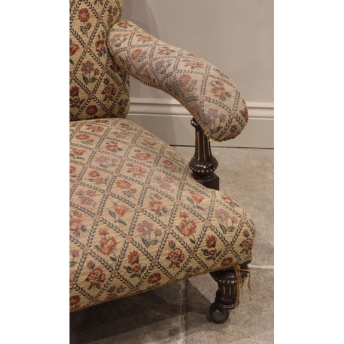 701 - A Victorian drawing room chair, the button back extending to down swept padded arms raised upon pain... 