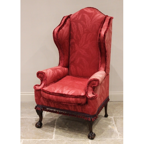 710 - A Queen Anne style wing back fireside armchair, early 20th century, covered in red damask foliate pa... 