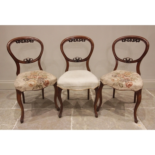 674 - A set of three late 19th century walnut dining chairs, each with foliate carved balloon backs and se... 