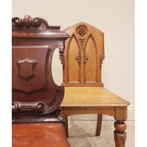 707 - A Victorian mahogany hall chair, the shield shaped back with scrolled detail above a moulded serpent... 