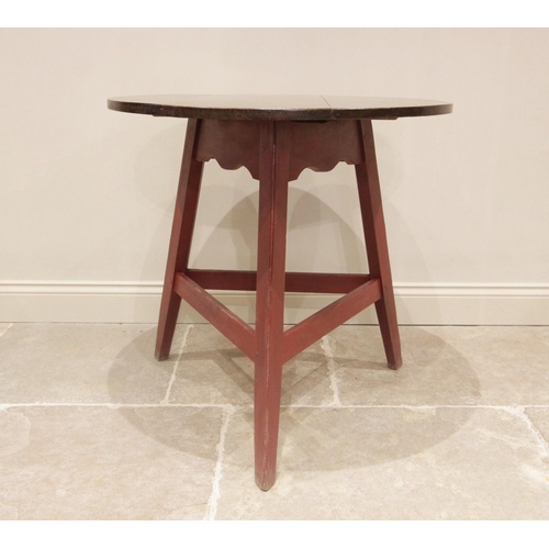 709 - A 19th century and later oak and painted cricket table, the circular oak top raised upon an associat... 