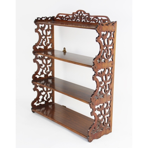 724 - A Victorian rosewood wall hanging shelf, the four graduated shelves united by scrolling fretwork sup... 