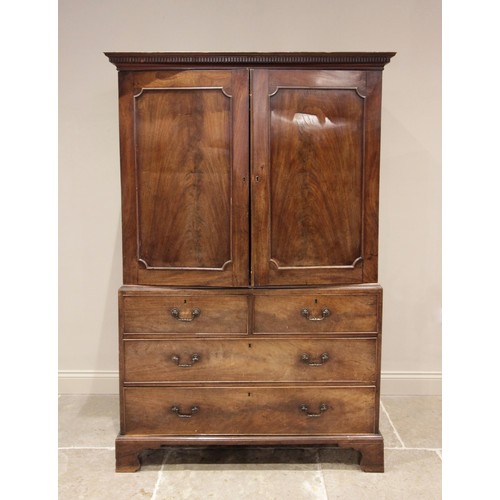 718 - A 19th century mahogany linen press, the dentil cornice above a pair of cupboard doors, applied with... 