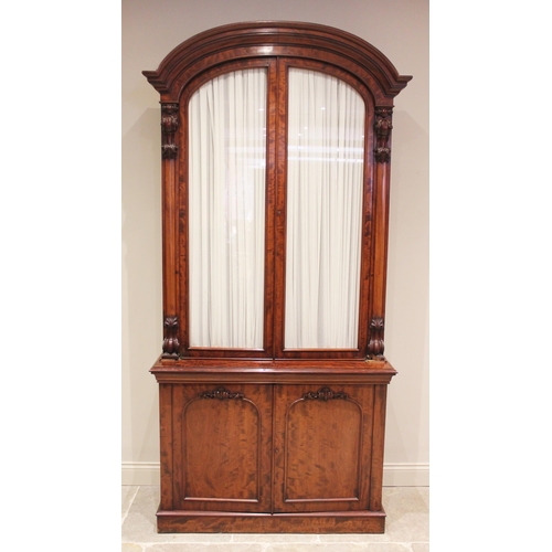 670 - A Victorian mahogany library bookcase, the arched moulded cornice above a pair of fabric lined glaze... 