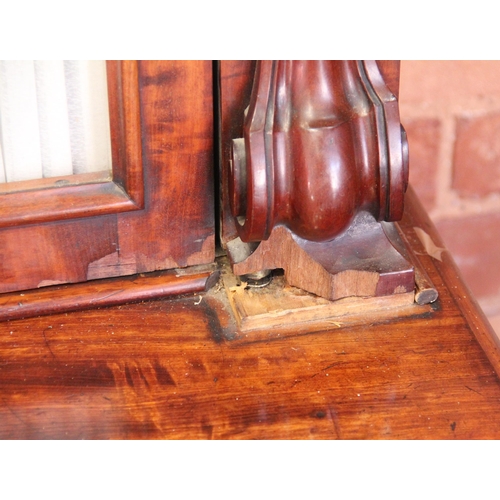 670 - A Victorian mahogany library bookcase, the arched moulded cornice above a pair of fabric lined glaze... 