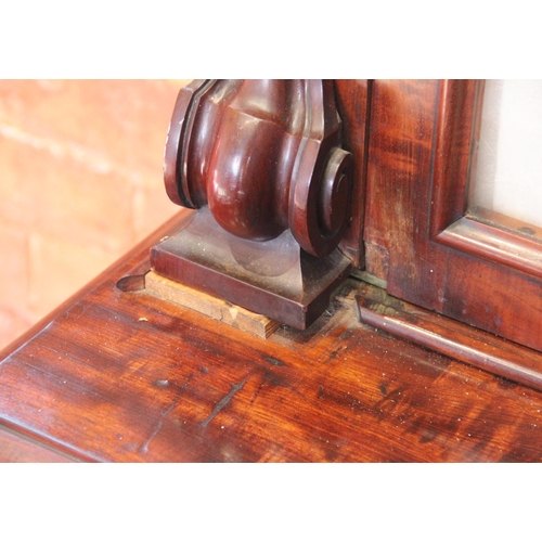 670 - A Victorian mahogany library bookcase, the arched moulded cornice above a pair of fabric lined glaze... 