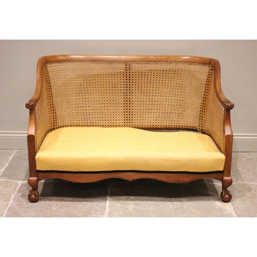 694 - A stained beech wood  bergère sofa, early 20th century, the curved back rail extending to egg and cl... 