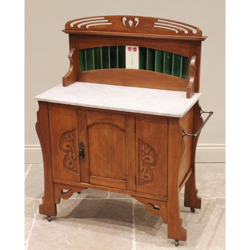 704 - An early 20th century satin walnut marble top and tile back washstand, the pierced pediment above a ... 