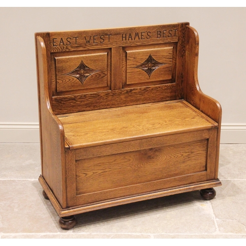 710 - A reproduction oak box settle, 20th century, the panel back carved 'East west hame's best' over twin... 