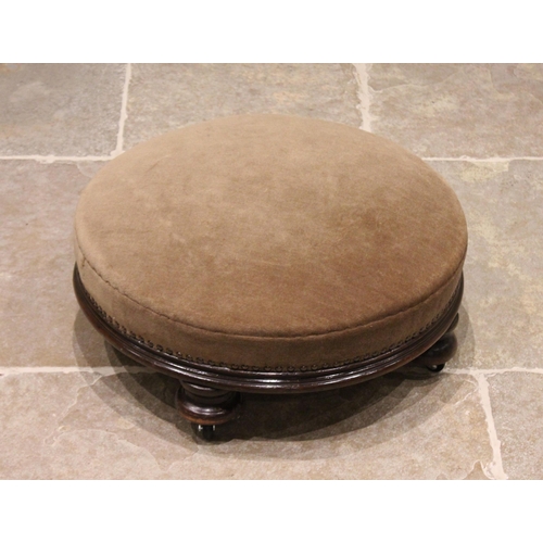 716 - A Victorian mahogany framed upholstered circular footstool, the sprung seat above a channelled apron... 