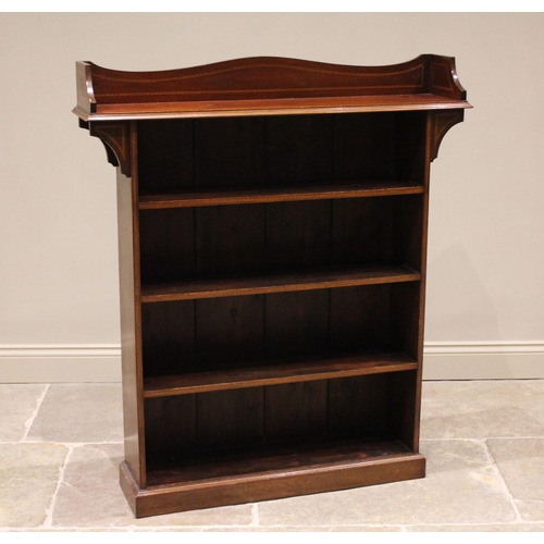 722 - An Edwardian mahogany Arts and Crafts inspired open bookcase, the overhanging top with a shaped thre... 