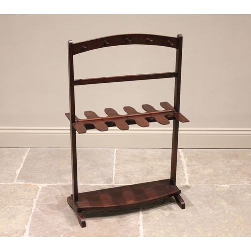 723 - An early 20th century mahogany boot and whip rack, with an arrangement of ten whip/crop pegs and rec... 