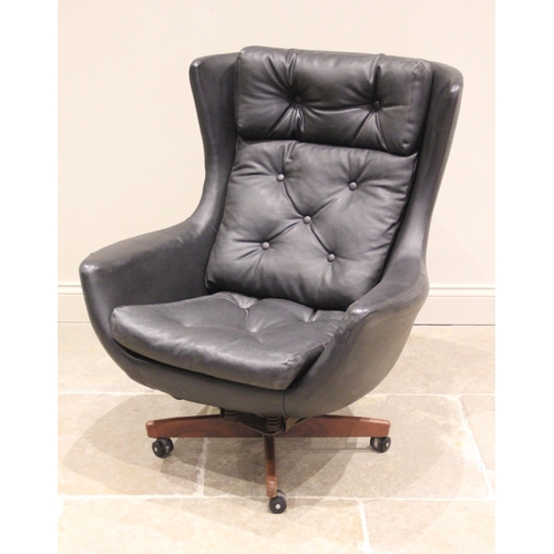 729 - A 1960's/1970's G-Plan type revolving black leather armchair, the button back extending to angular w... 