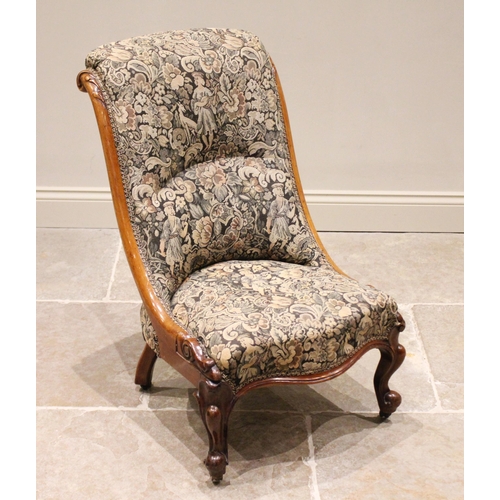 676 - A Victorian mahogany low seat nursing chair, in tapestry style fabric, the curved side rails carved ... 