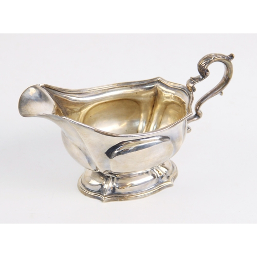 1 - A George V silver sauce boat by Carrington & Co, London 1913, of shaped oval form on pedestal foot w... 