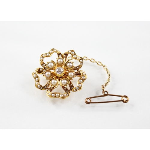 110 - An Edwardian diamond and pearl floral pendant brooch, the central old cut diamond set to a yellow me... 