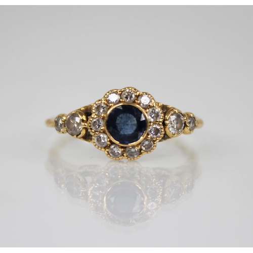 117 - An early 20th century sapphire and diamond floral cluster ring, the central round mixed cut sapphire... 