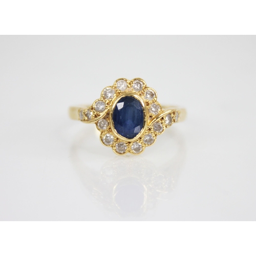 118 - A sapphire and diamond 18ct gold cluster ring, the central oval mixed cut sapphire measuring 6.5mm x... 