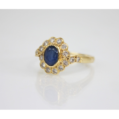 118 - A sapphire and diamond 18ct gold cluster ring, the central oval mixed cut sapphire measuring 6.5mm x... 