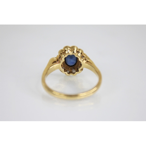 118 - A sapphire and diamond 18ct gold cluster ring, the central oval mixed cut sapphire measuring 6.5mm x... 