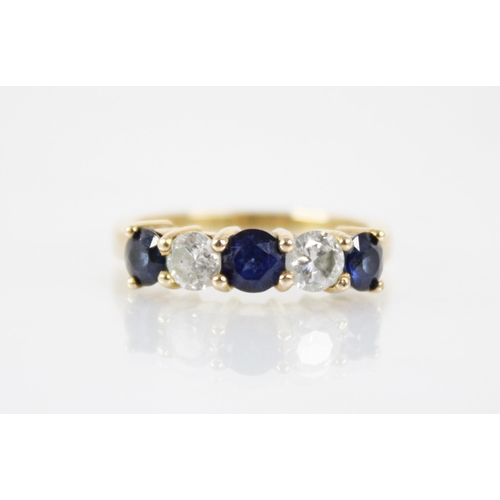 123 - A sapphire and diamond five stone ring, the central round mixed cut blue sapphire measuring 4.6mm di... 