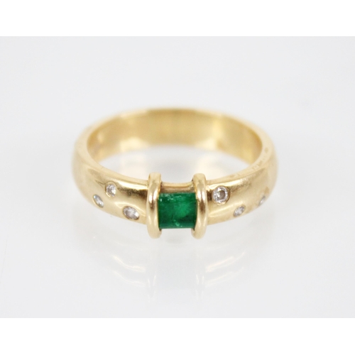 124 - An emerald and diamond ring, the central rectangular step cut emerald measuring 3.8mm x 4.8mm, to an... 