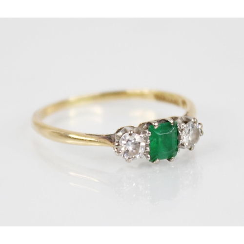 125 - An emerald and diamond three stone ring, the central rectangular step cut emerald measuring 4.5mm x ... 