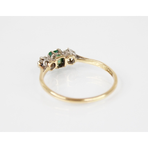 125 - An emerald and diamond three stone ring, the central rectangular step cut emerald measuring 4.5mm x ... 