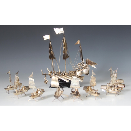 20 - A Chinese silver coloured model of a junk ship, modelled with three masts in full sail, eight ores a... 