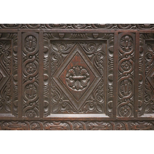 584 - A late 17th century/early 18th century carved oak coffer, the three panel cover opening to a fitted ... 