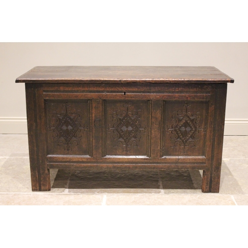 587 - An early 18th century oak coffer, the three plank top opening to a fitted candle box, above the thre... 