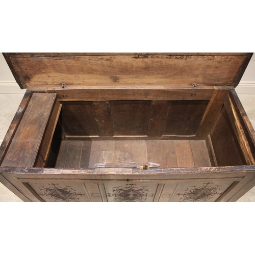 587 - An early 18th century oak coffer, the three plank top opening to a fitted candle box, above the thre... 