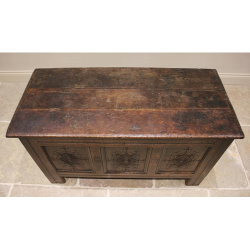 587 - An early 18th century oak coffer, the three plank top opening to a fitted candle box, above the thre... 