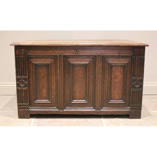 588 - An early 18th century oak coffer, the rectangular moulded top over three front panels, enclosed by f... 