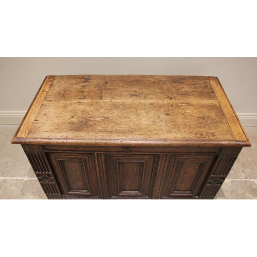 588 - An early 18th century oak coffer, the rectangular moulded top over three front panels, enclosed by f... 