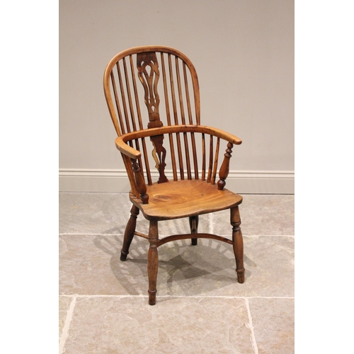 589 - A 19th century yew and ash hoop back Windsor elbow chair, with a pierced splat over a shaped seat ra... 