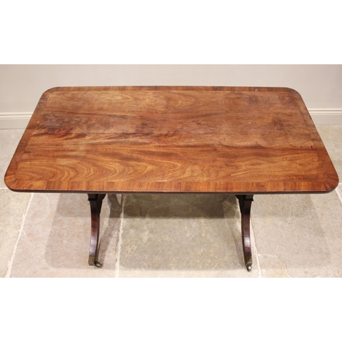 594 - A George IV mahogany side table, the rectangular cross banded top with rounded corners raised upon a... 